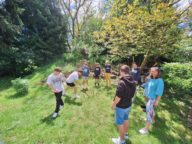 Burschen der 4b und Frau Direktor im Garten beim Teamwork